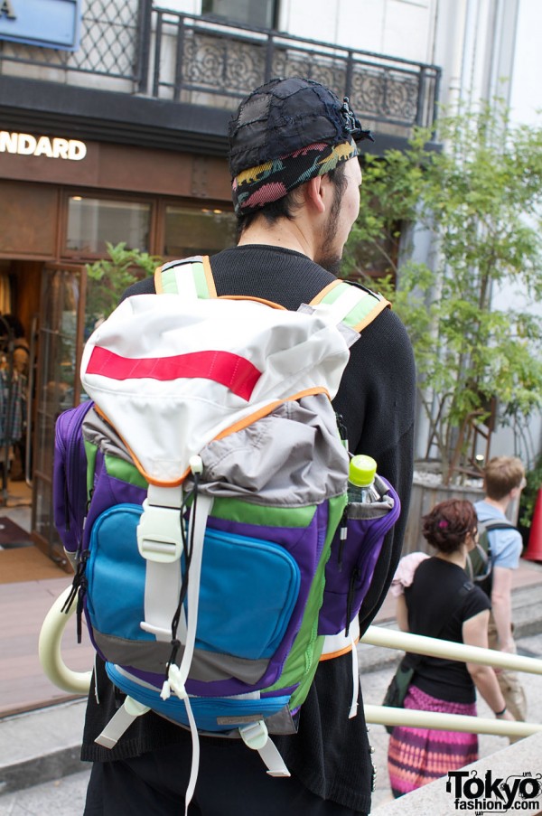 Brightly colored backpack and black patchwork hat