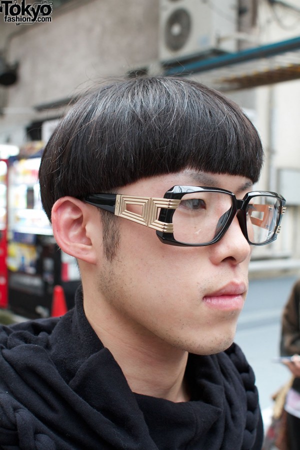 Bowl haircut & gold-trimmed glasses