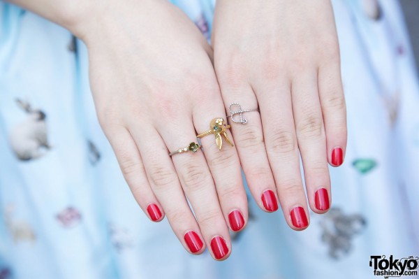 Red nail polish & delicate rings