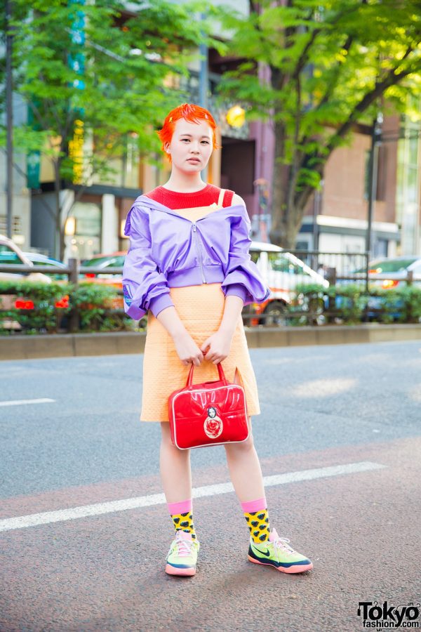 Orange Pixie-Haired Girl in Mizuno Off-Shoulder Jacket, Orange Dress, Happy Socks & Nike Colorblock Sneakers