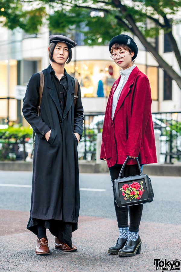 Japanese Duo in Long Coat, Asymmetrical Skirt, Corduroy Jacket w/ Badges, Suede Satchel Backpack, Newsboy Caps & Floral Applique Handbag