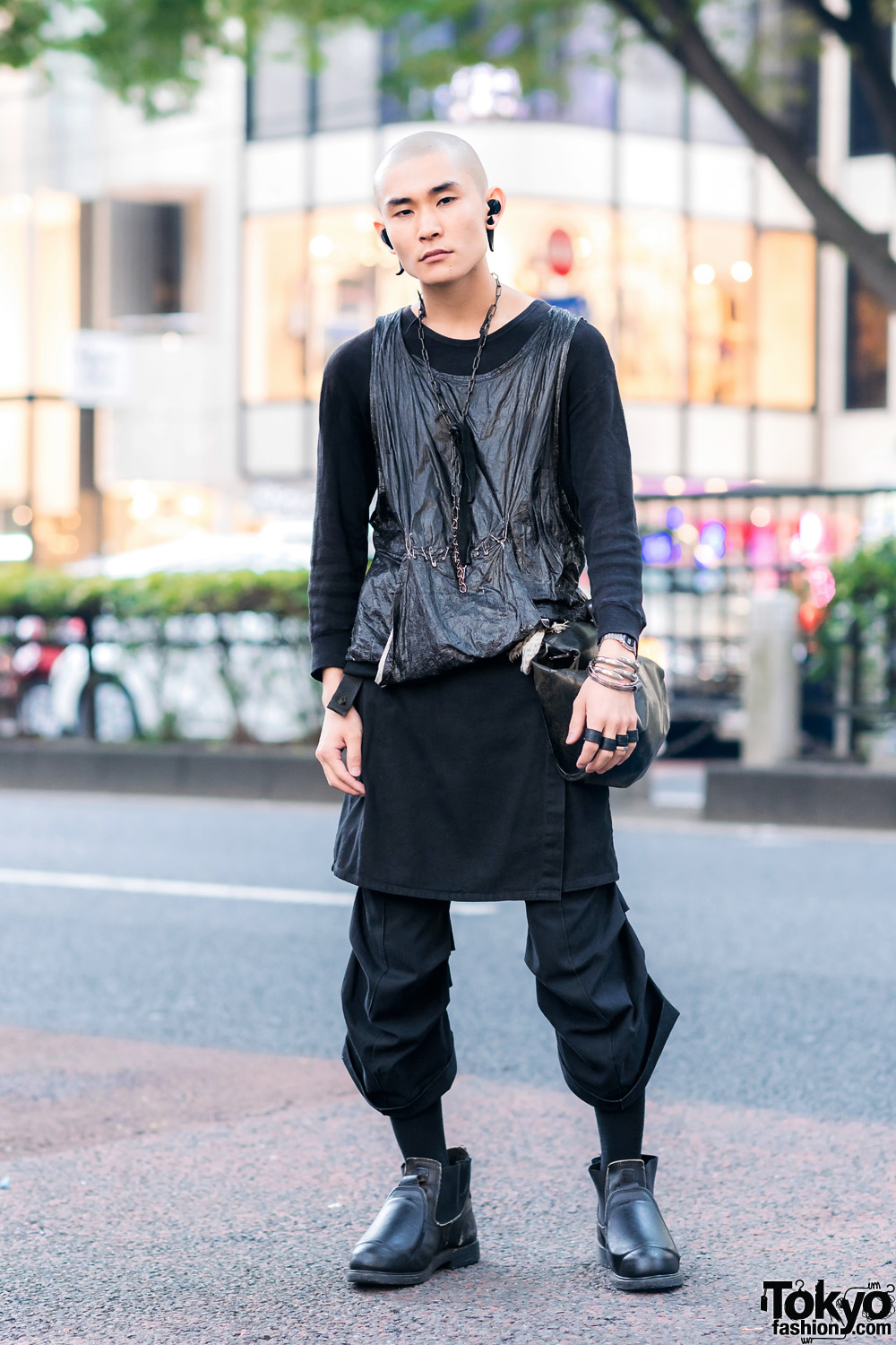 All Black Layered Harajuku Streetwear Style w/ Shaved Head, Horn Earrings, Shiny Tank , Skirt Over Cropped Pants, Leather Waist Bag & Chelsea Boots
